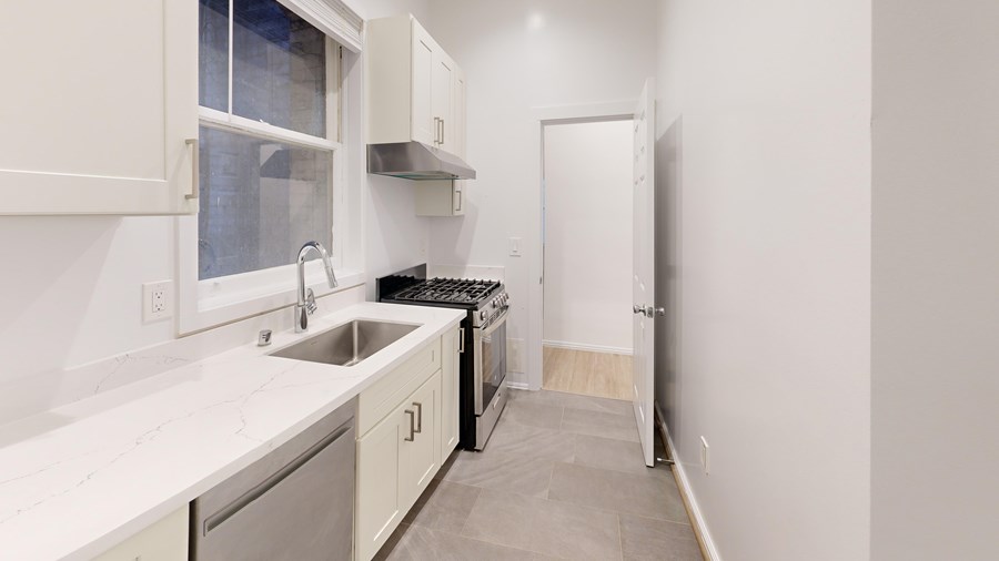 A kitchen with white cabinets and a black dishwasher.